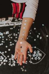 Midsection of woman with tattoo on table