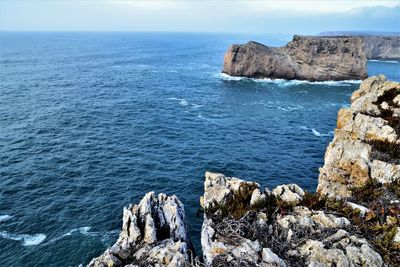 Scenic view of rocks in sea against sky