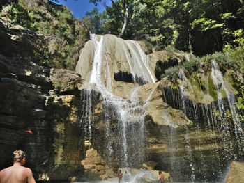 Water splashing on rocks against waterfall