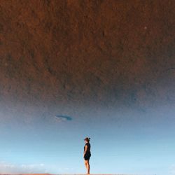 Rear view of man standing against clear sky