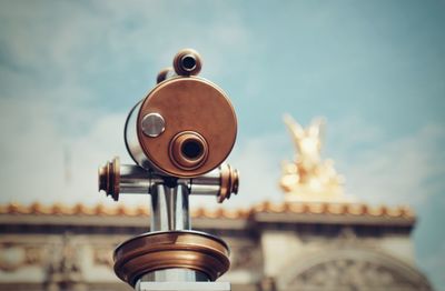 Close-up of coin-operated binoculars against sky