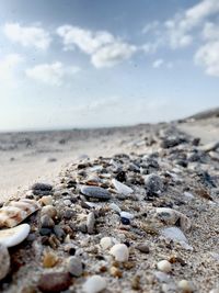 Surface level of stones at beach against sky