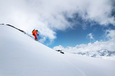 Person skiing on snowcapped mountain against sky