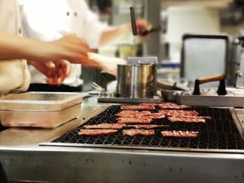 Man preparing food on barbecue grill in kitchen