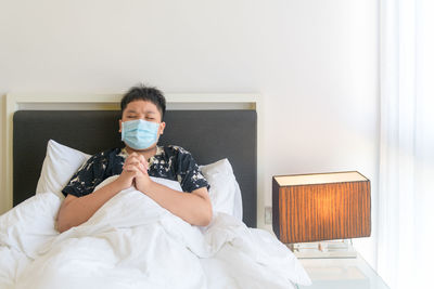 Portrait of man sitting on bed