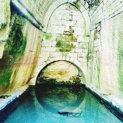 Reflection of old bridge in water