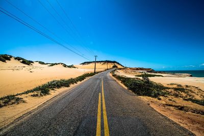 Road amidst landscape against clear blue sky