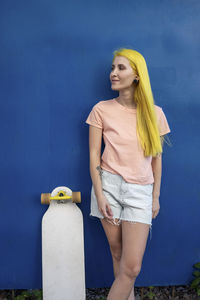 Woman standing against blue wall