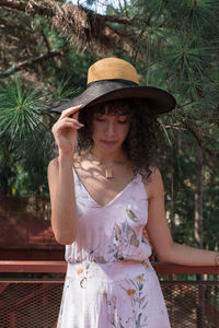 Portrait of woman wearing hat against trees