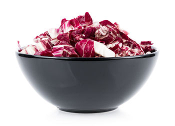 Close-up of chopped cabbage in bowl against white background