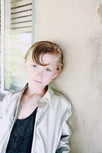 Portrait of boy leaning on wall