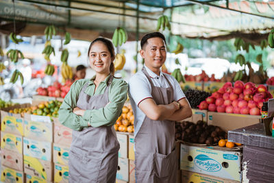 Portrait of smiling young woman standing in market