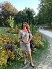 Portrait of smiling woman standing against plants