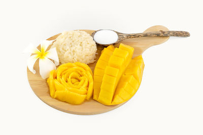 High angle view of yellow slices in bowl against white background