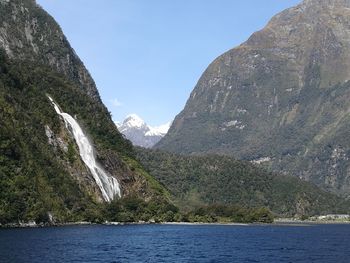 Scenic view of sea and mountains against clear sky