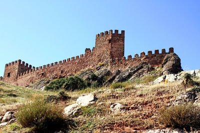 Low angle view of fort against clear blue sky