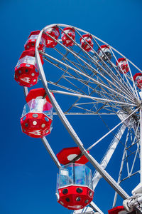 Low angle view of ferris wheel against clear blue sky