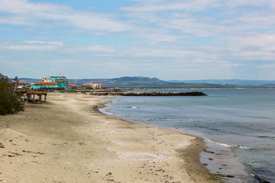 Scenic view of beach against cloudy sky