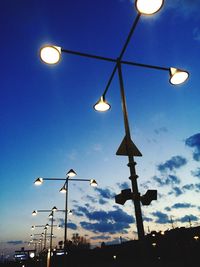 Low angle view of illuminated street light against blue sky