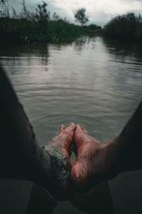 Cropped hand of person in lake