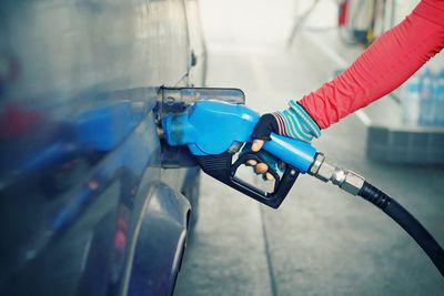 Close-up of person refueling car at gas station