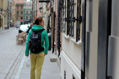 Rear view of woman walking on sidewalk