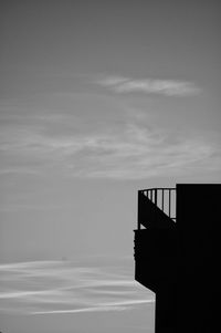 Silhouette built structure by sea against sky