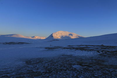 Scenic view of mountains against clear blue sky