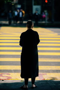 Rear view of woman standing on street