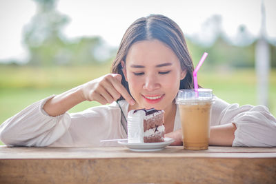 Close-up of woman sitting with breakfast on table at restaurant