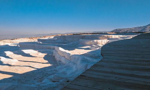 Scenic view of snowcapped mountains against clear blue sky