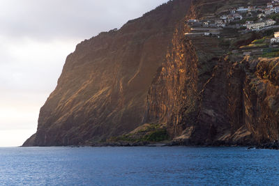 Scenic view of sea and mountains against sky