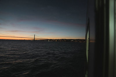 Bridge over sea against sky during sunset