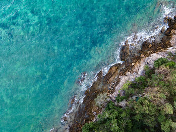 The top view of beautiful blue seashore and rocky on coast and white bungalow on the beach