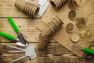 Top view of seeds and garden tools on a wooden background. growing seedlings using peat cups.