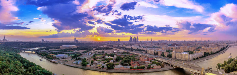 Wide angle vibrant panorama of moscow river and downtown under dramatic cloudy sky