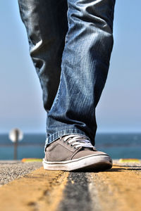 Low section of man standing by water