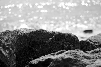 Close-up of rocks by sea against sky