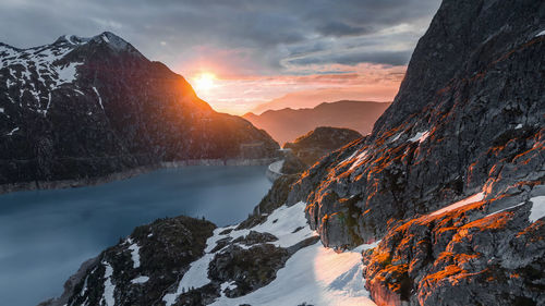 Scenic view of snowcapped mountains against sky during sunset