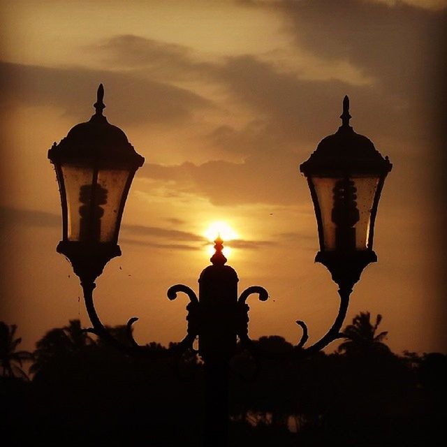 silhouette, sunset, lighting equipment, sky, street light, low angle view, sun, lantern, lamp post, orange color, illuminated, built structure, cloud - sky, dusk, electric lamp, tranquility, nature, outdoors, no people, sunlight