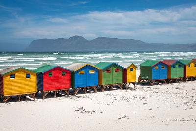 Famous colorful beach houses in muizenberg near cape town, south africa against blue sky with clouds