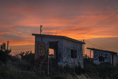 Abandoned building against sky during sunset