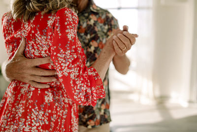 Midsection of senior woman dancing with man in dance class