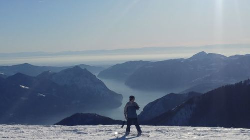 Man standing on mountain by sea against sky