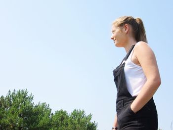 Side view of woman looking away against clear sky