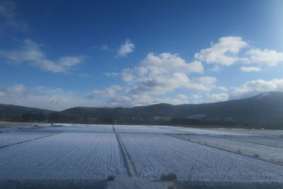 Scenic view of snowy field against sky