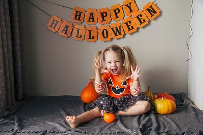 A little girl in a pumpkin costume for halloween, trick or treat. children celebrate halloween