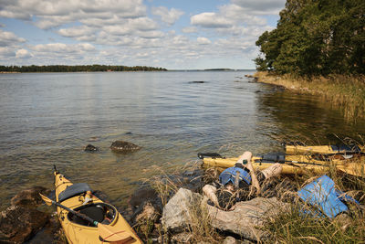 Man at lake relaxing near kayaks during sunny day