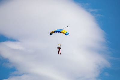 Low angle view of person paragliding against sky