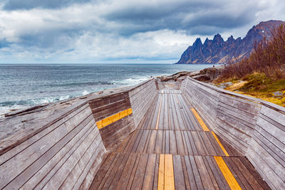 Boardwalk on beach against sky